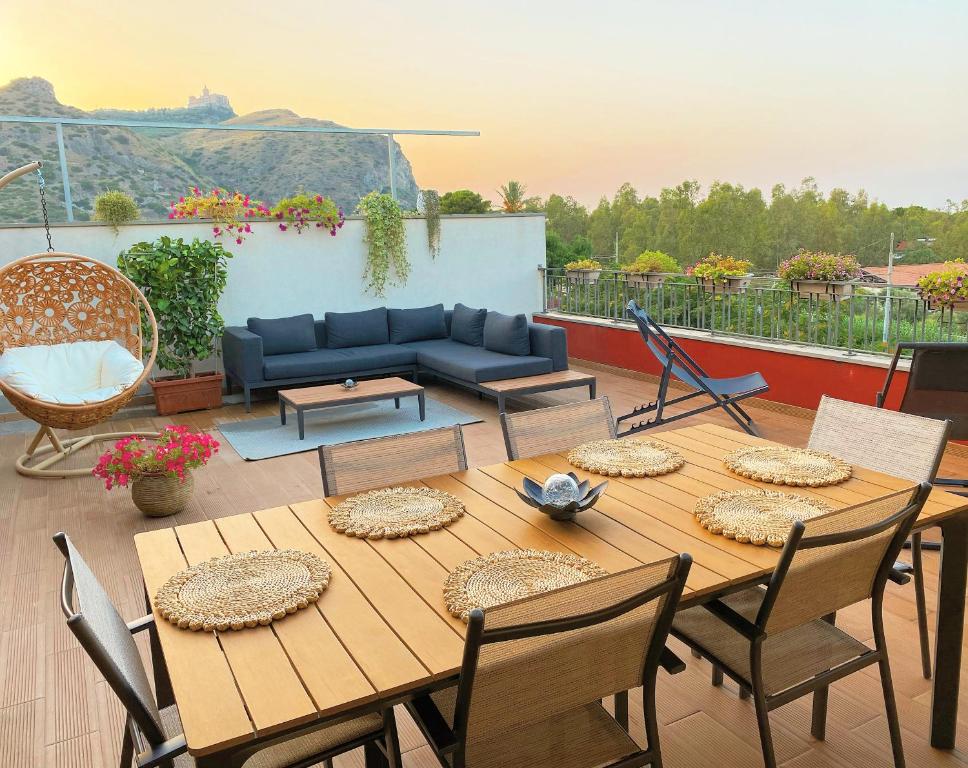 eine Terrasse mit einem Tisch, Stühlen und einem Sofa in der Unterkunft La Casa Di Rosa in Oliveri