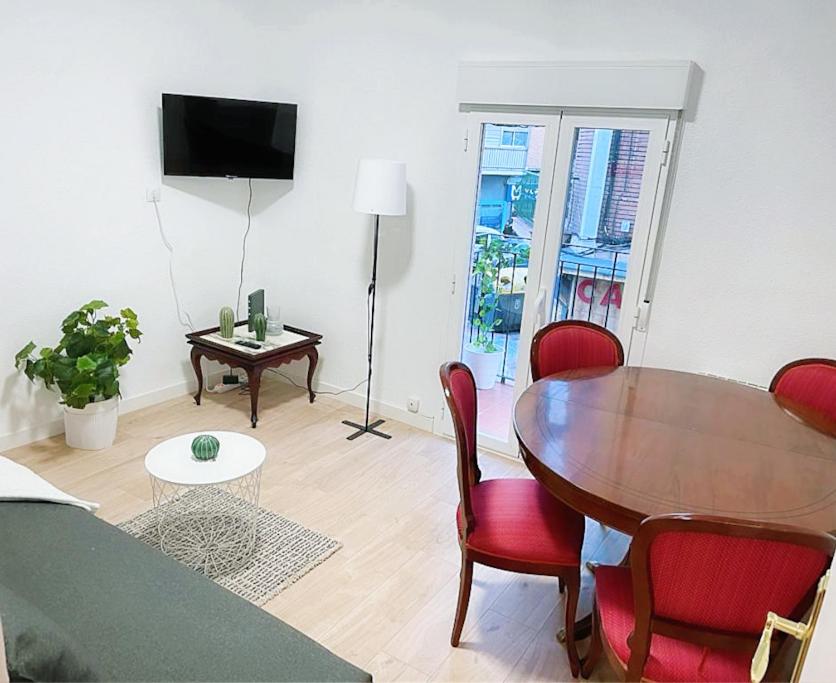 a living room with a wooden table and red chairs at AR2 Luminoso piso de 3 habs con balcón y WIFI in Madrid