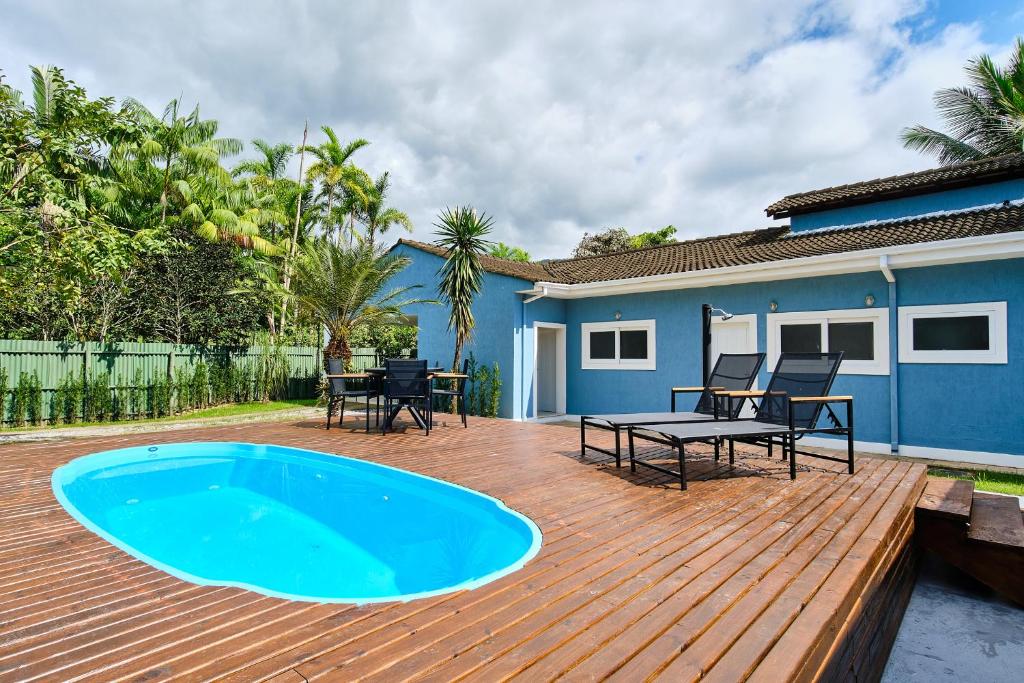 a deck with a pool and a table and chairs at Casa Caminho da Praia 3 quartos com ar no Cabore in Paraty