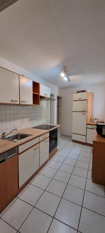 uma grande cozinha com armários e electrodomésticos brancos em Ferienzimmer in der Altstadt em Wangen im Allgäu