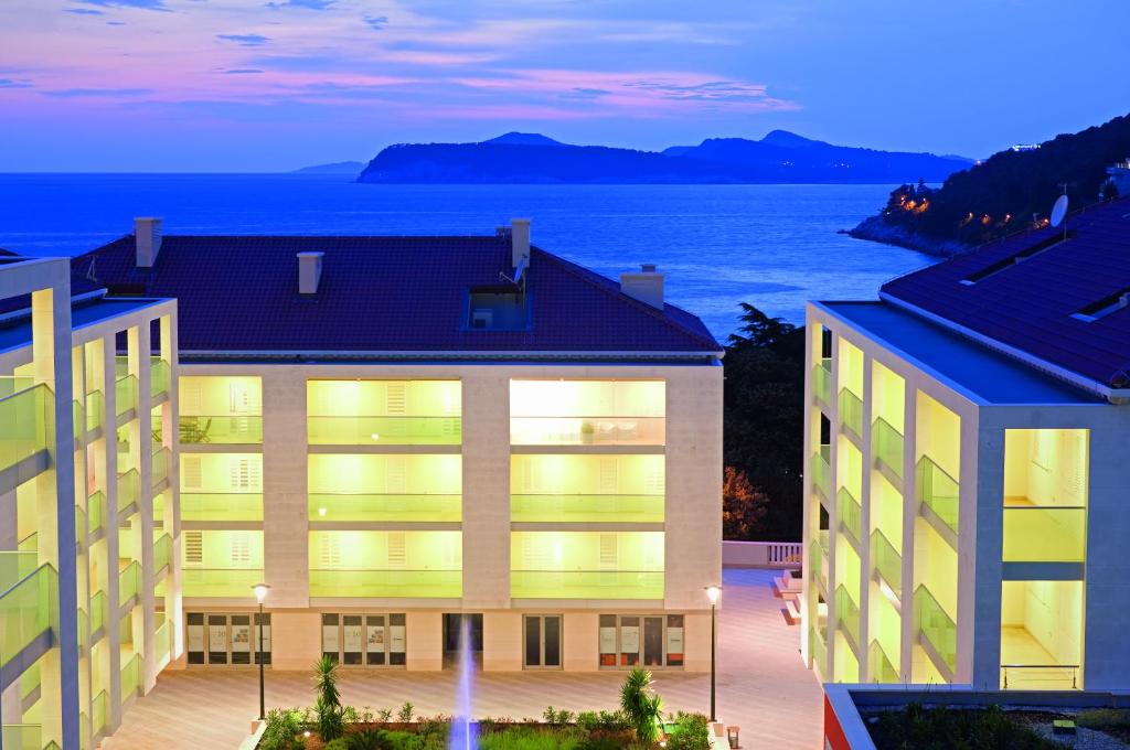 a building with a view of the ocean at night at Dubrovnik Luxury Residence – L’Orangerie in Dubrovnik