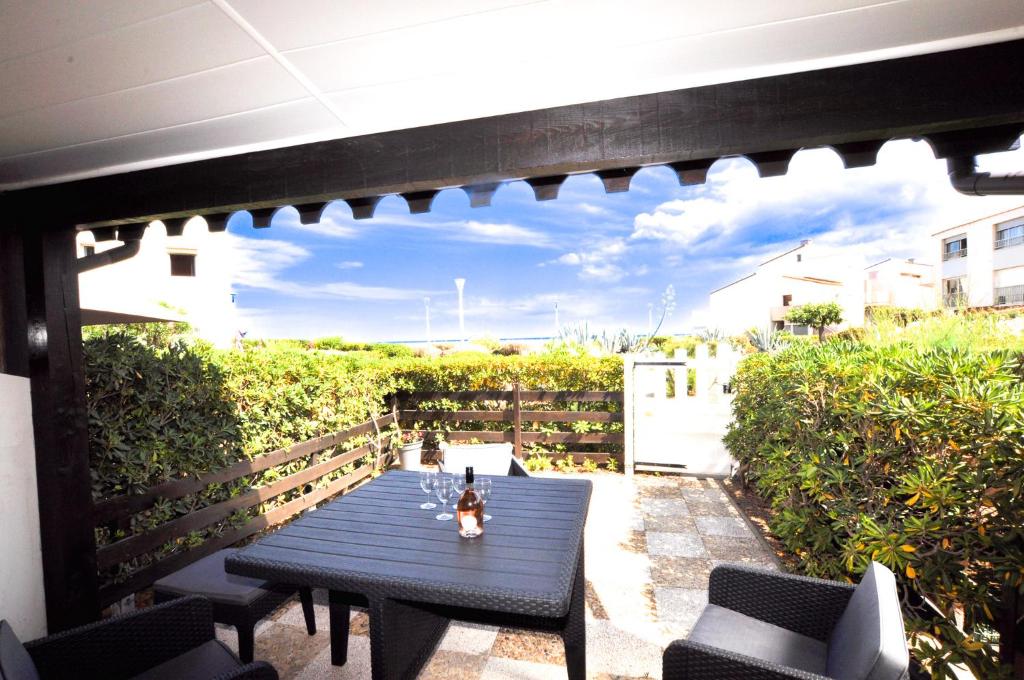 d'une terrasse avec une table et des chaises bleues. dans l'établissement Maison gde terr. front de mer - 4 couchages, à Leucate