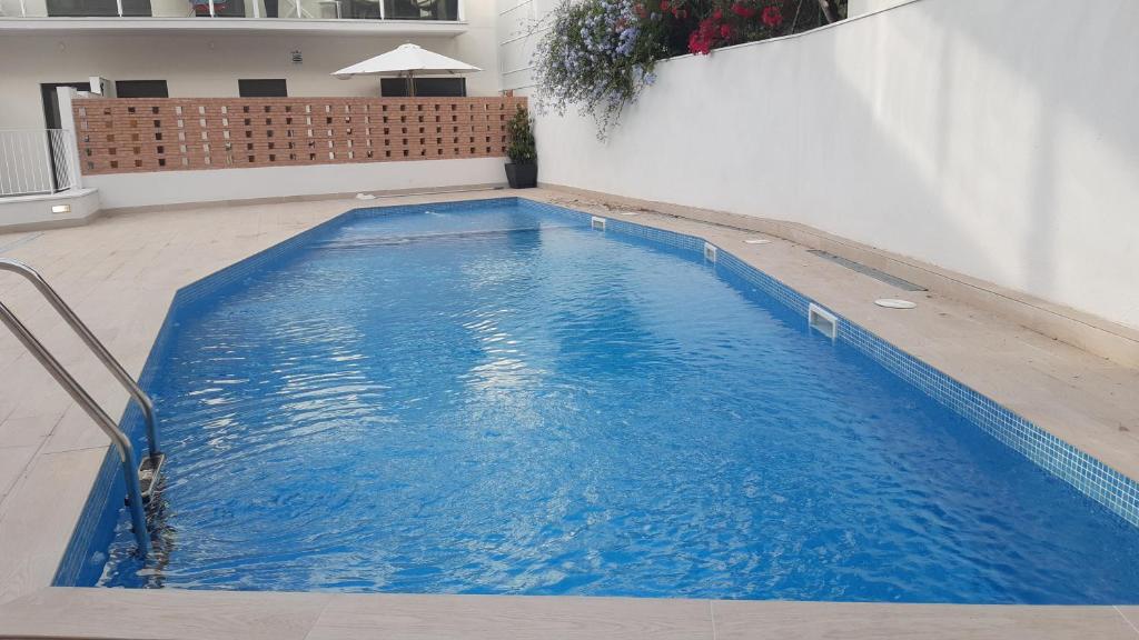 duży niebieski basen w budynku w obiekcie Nuevo con Piscina en el centro y cerca de la playa w mieście Vilanova i la Geltrú