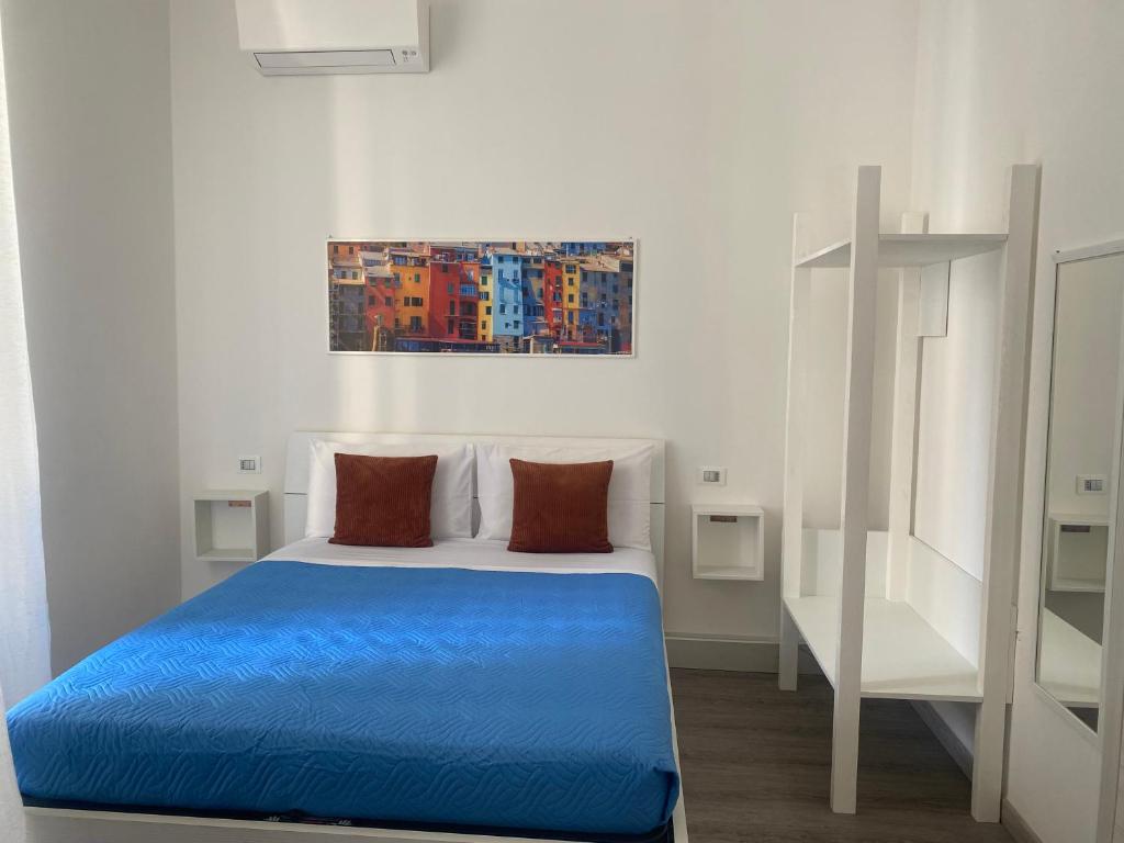 a bedroom with a blue bed and a painting on the wall at Titi Rooms in La Spezia