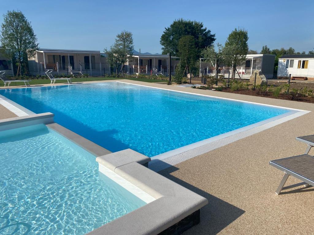 a large swimming pool with blue water in a yard at Agricamping Zanina 9 in Peschiera del Garda