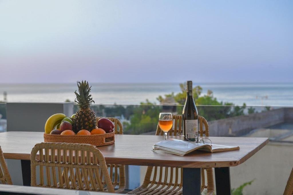 una mesa con una cesta de fruta y una botella de vino en Leon Luxury Home in Rethymno en Gállos