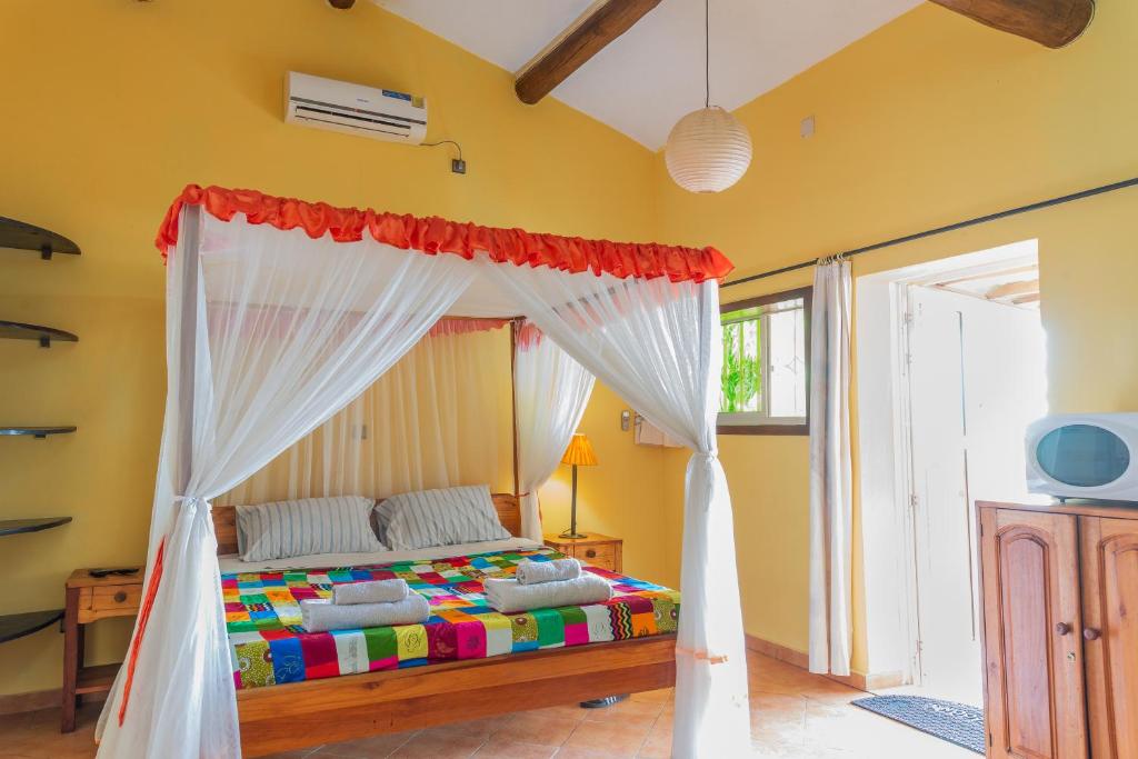 a bedroom with a bed with a canopy at Aparthotel Jardin Tropical in Bujumbura