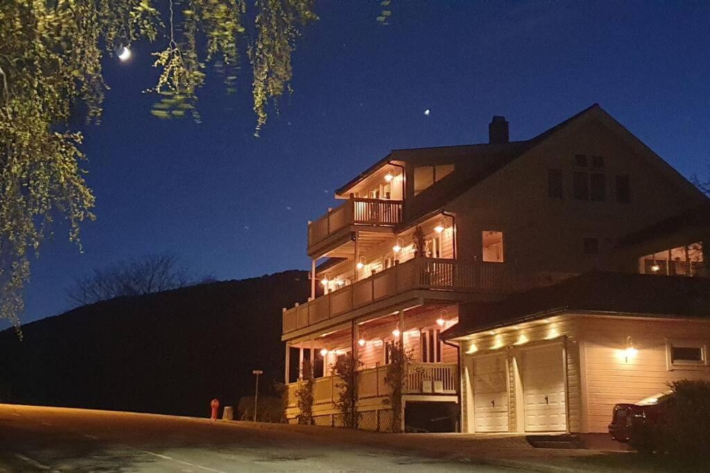 une grande maison éclairée la nuit avec des lumières dans l'établissement Moen Booking, à Åndalsnes