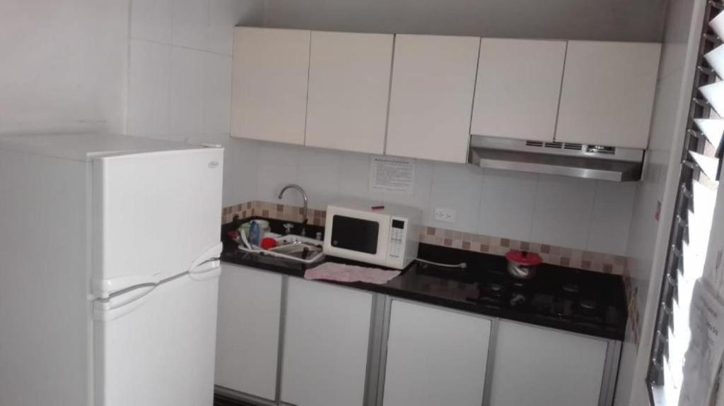a small kitchen with white cabinets and a microwave at Apartamento 4 Habitaciones Sector Estrato 5 Laureles in Medellín