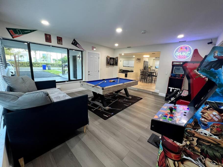 Modern Tropical Oasis with Arcade, HotTub & MiniGolf في هوليوود: غرفة معيشة مع طاولة بلياردو وألعاب فيديو