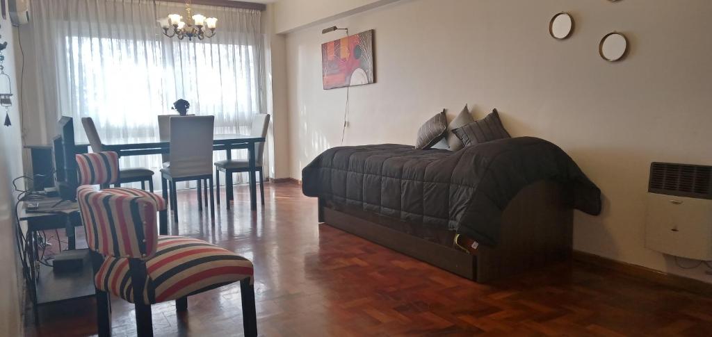 sala de estar con cama, mesa y sillas en Altos Mendoza Av Gutiérrez Cochera Gratis! en Mendoza