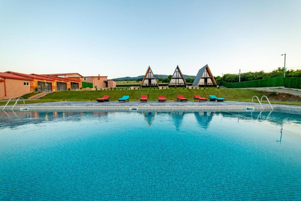 una gran piscina con sillas rojas y azules en TITA HOMES, en Telavi