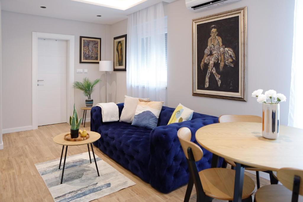 sala de estar con sofá azul y mesa en Treetop Apartments en Vršac