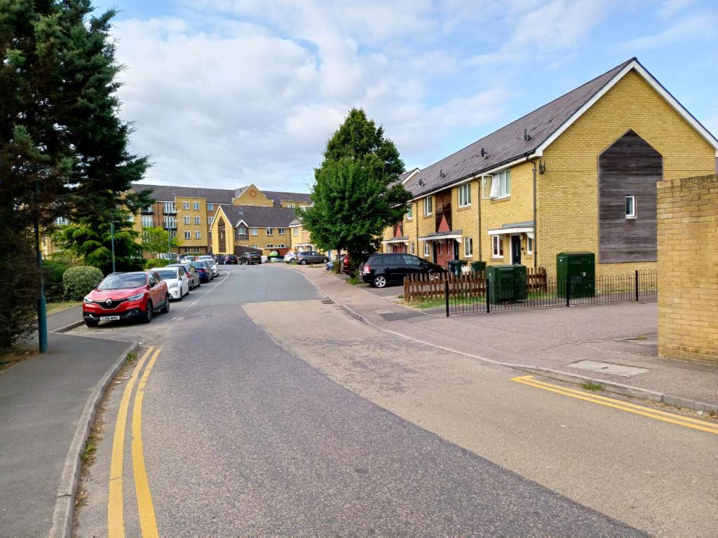 una calle en un barrio residencial con coches aparcados en Dreams Home en Northfleet