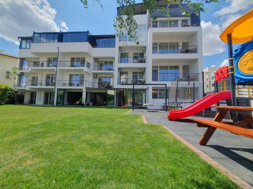 un immeuble d'appartements avec une aire de jeux et un toboggan dans l'établissement MIANELLY Apartments Mamaia Nord, à Mamaia Nord – Năvodari