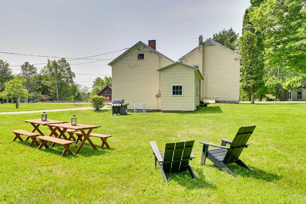 een picknicktafel en stoelen in een veld met een gebouw bij Charming Historic Home Less Than 4 Mi to Cooperstown! in Fly Creek