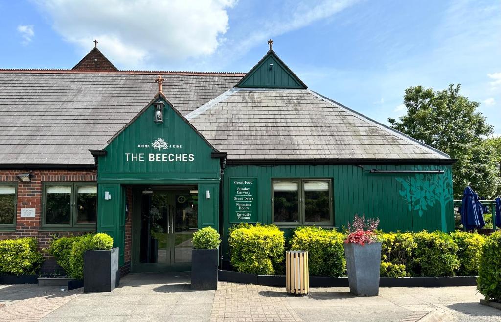 um edifício verde com um sinal que lê os cervejeiros em The Beeches, Ashby-de-la-Zouch em Ashby de la Zouch