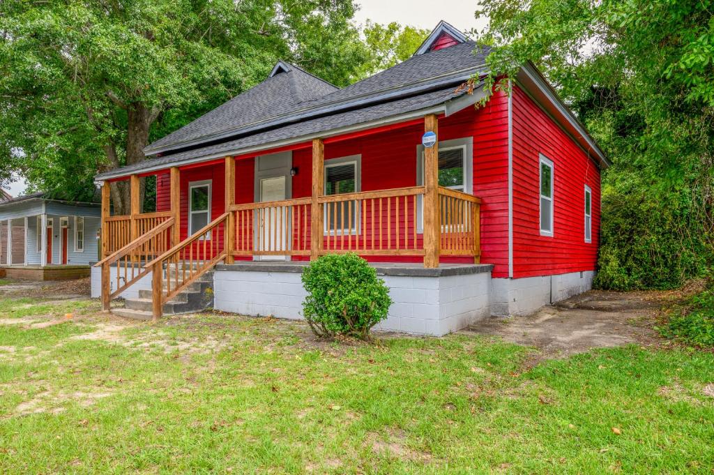 una casa roja con una gran terraza en un patio en Macon Cottage with Porch - 2 Mi to Downtown!, en Macon