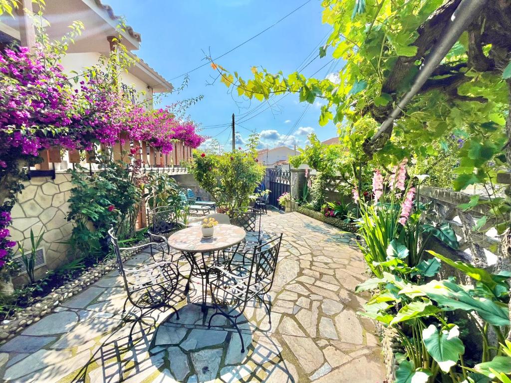 a patio with a table and chairs in a garden at La Casa de la Buganvilla in Gijón