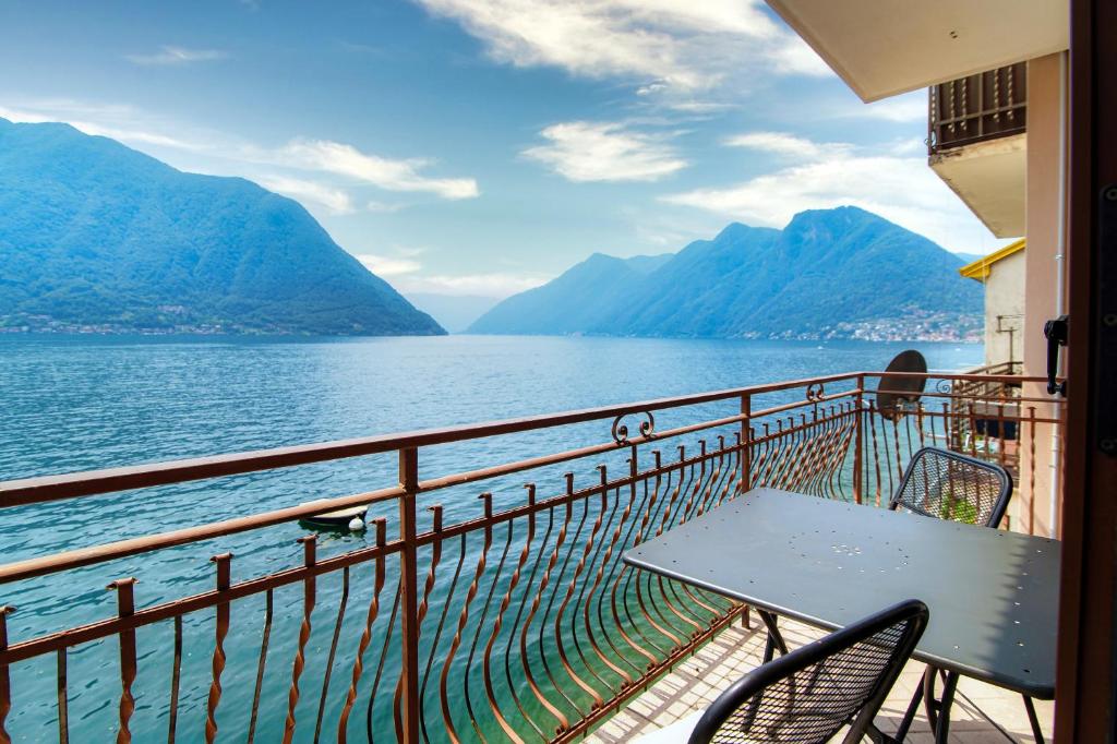 a table and chairs on a balcony overlooking a lake at Da Flora Wonderful Lakefront View in Colonno