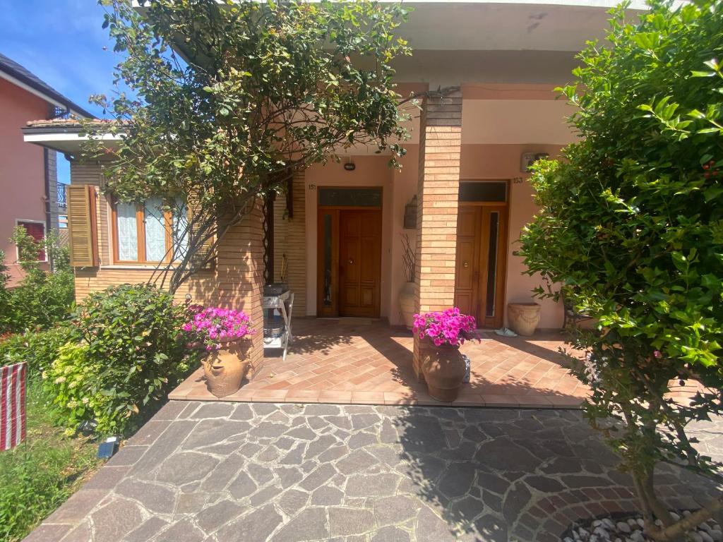 een huis met twee vazen bloemen op een patio bij Casa Rosati - Baia Flaminia in Pesaro