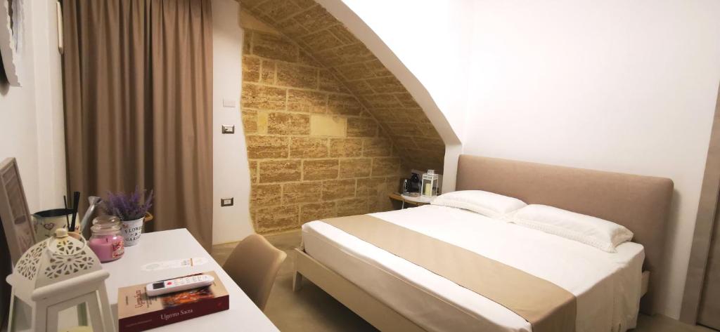 une chambre d'hôtel avec un lit et une table dans l'établissement TORRE VECCHIA RELAIS, à Ugento