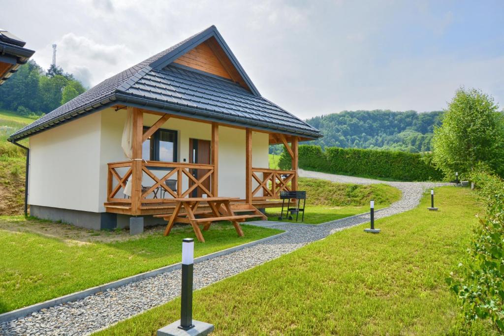 una pequeña cabaña en un campo con un camino en Brzozowa Osada en Polańczyk