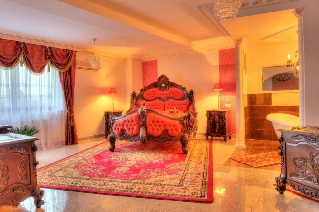 a bedroom with a red bed and a rug at Adria in Bieruń Nowy