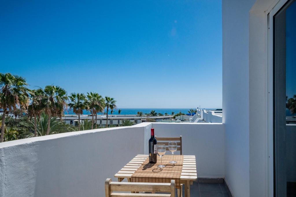 a table with a bottle of wine on a balcony at Miramar in Tarajalejo