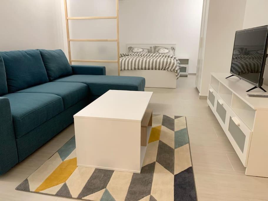 a living room with a blue couch and a tv at Charming intim apartment in Paris South in Montrouge