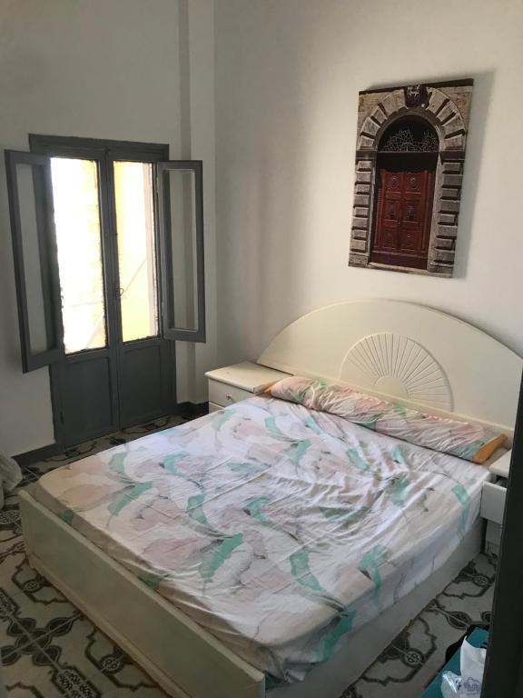 a bedroom with a bed in a room with two windows at شالية صف اول على البحر فى قرية الكرمة سيدى عبد الرحمن in El Alamein