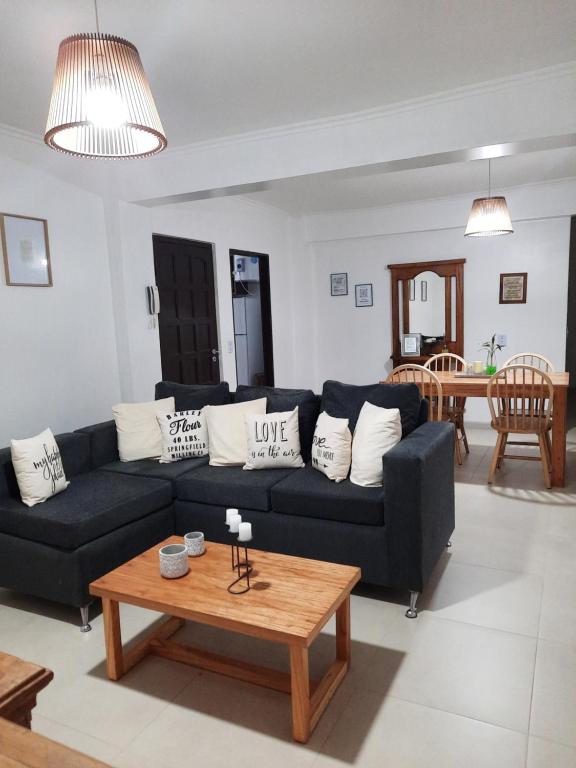 a living room with a black couch and a table at Las Arecas 2° B - Perito Moreno in Puerto Iguazú