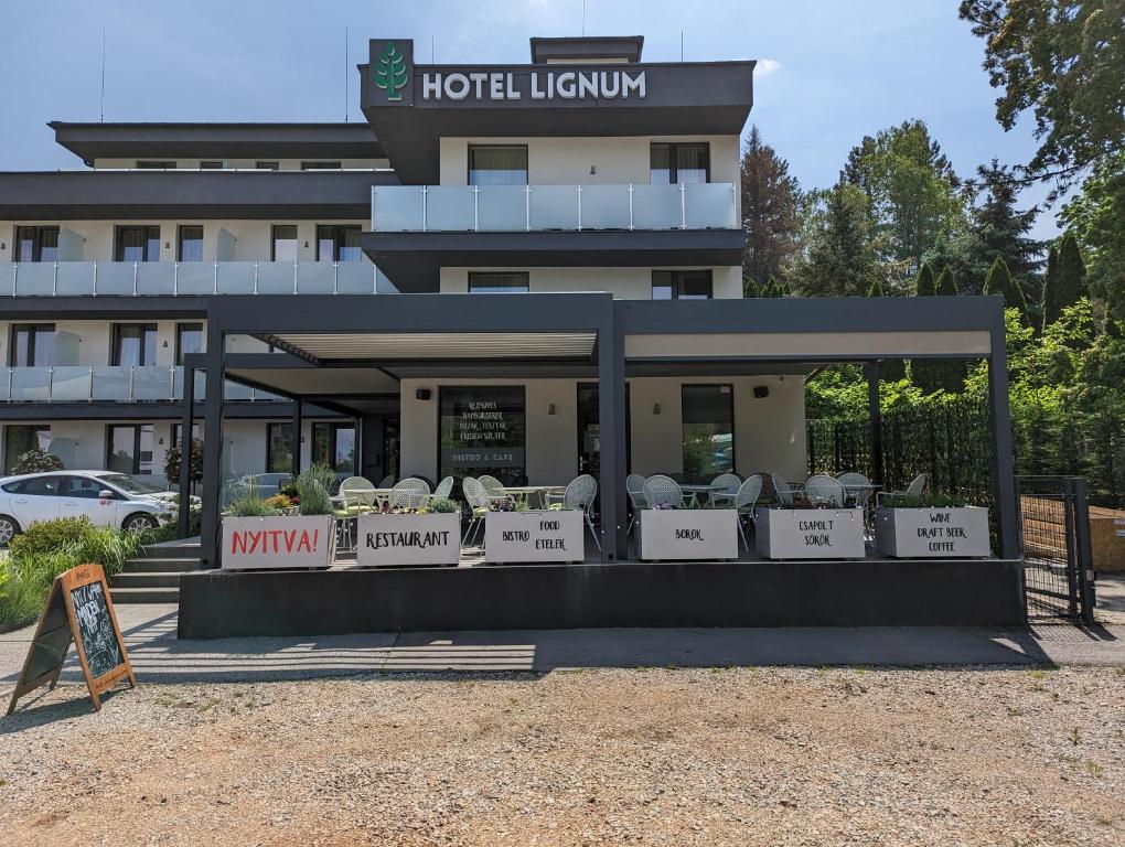 a hotel lobby with chairs in front of a building at Lignum Hotel in Miskolctapolca