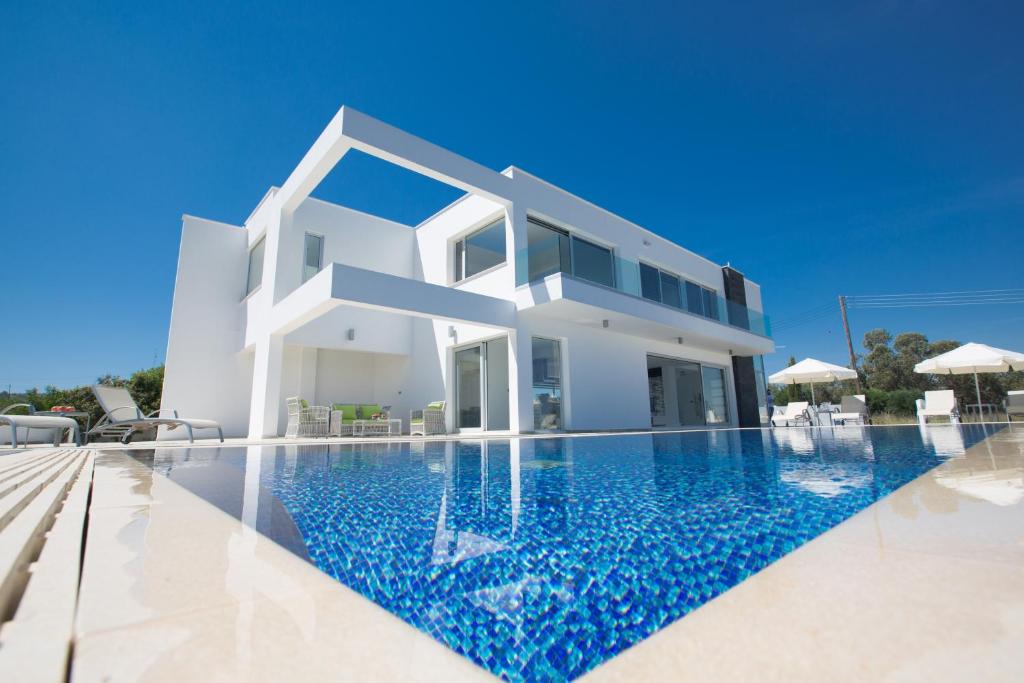 a villa with a swimming pool in front of a house at Villa Marilia in Protaras