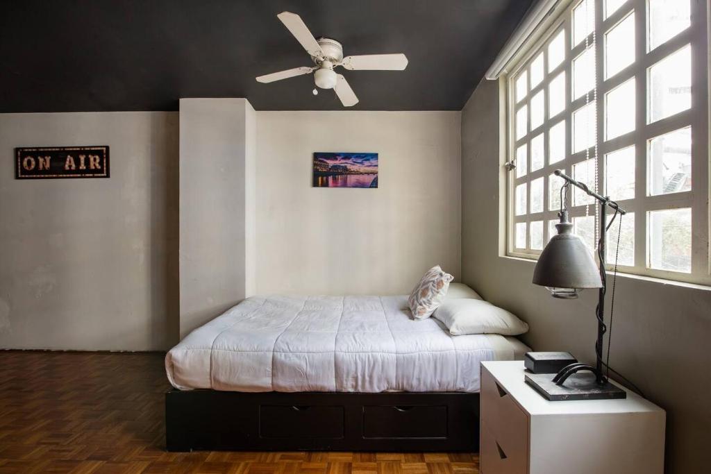 - une chambre avec un lit et un ventilateur de plafond dans l'établissement Del Lago Lofts, à Mexico