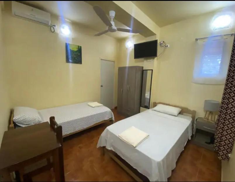 a room with two beds and a tv in it at Recover in Pucallpa