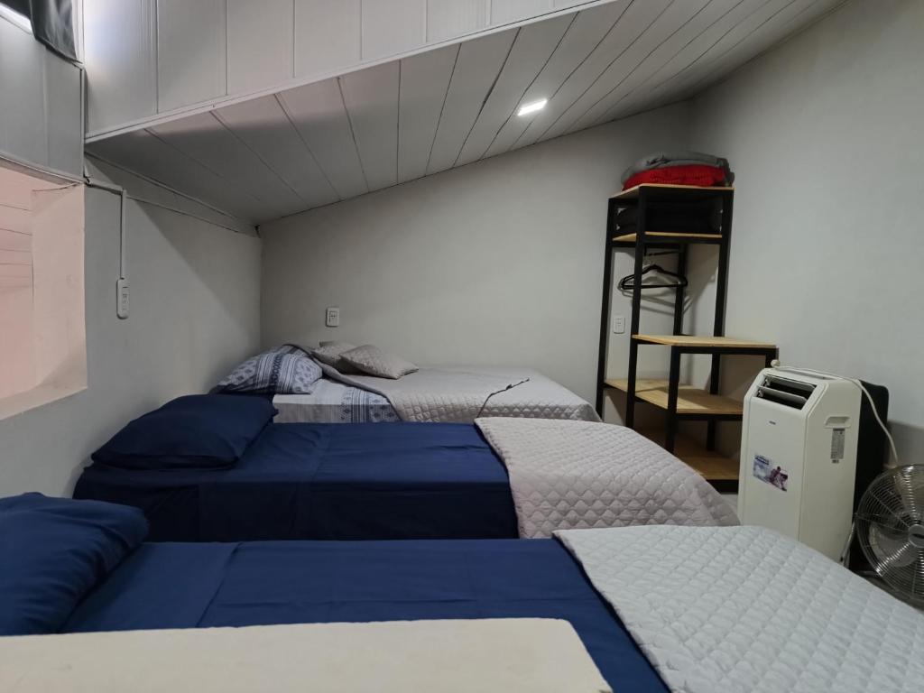 ein Schlafzimmer mit 2 Betten und einem Regal darin in der Unterkunft La Cascada 2 in Posadas