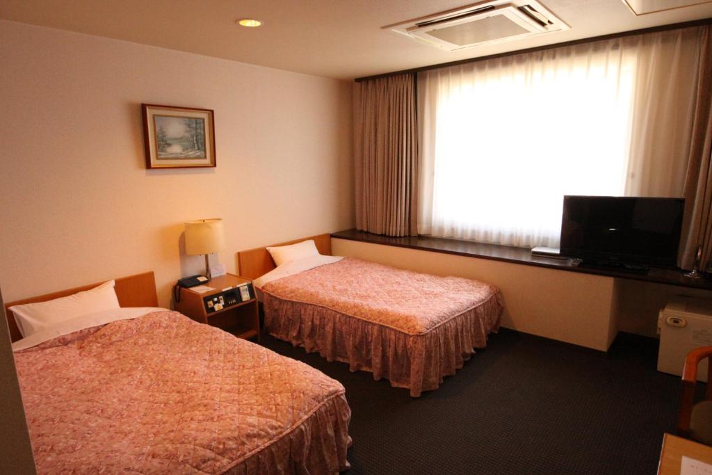 Postel nebo postele na pokoji v ubytování Shingu Central Hotel