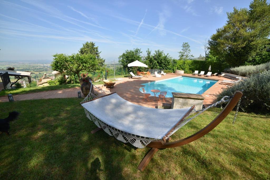 a yard with a swimming pool with a swing at Villa Clara in Assisi