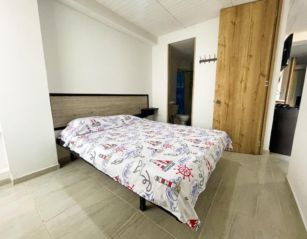 um quarto com uma cama com uma colcha em Comodidad y confort en el Quindío em Armênia