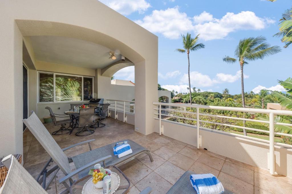 a balcony with a table and chairs and palm trees at Palms at Wailea 2108 in Wailea
