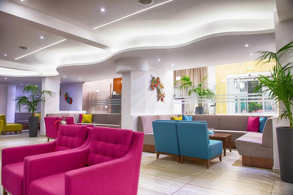 a waiting room with pink and blue chairs at New Famagusta Hotel & Suites in Ayia Napa