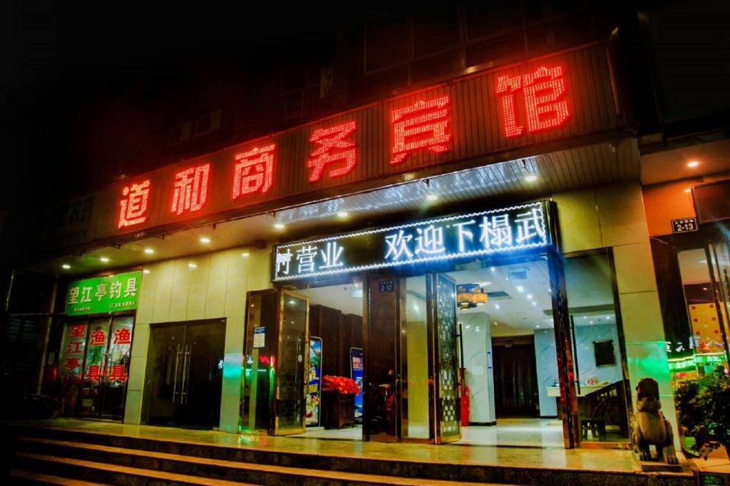a store with neon signs on the front of it at Wudangshan Daohe Inn in Danjangkou