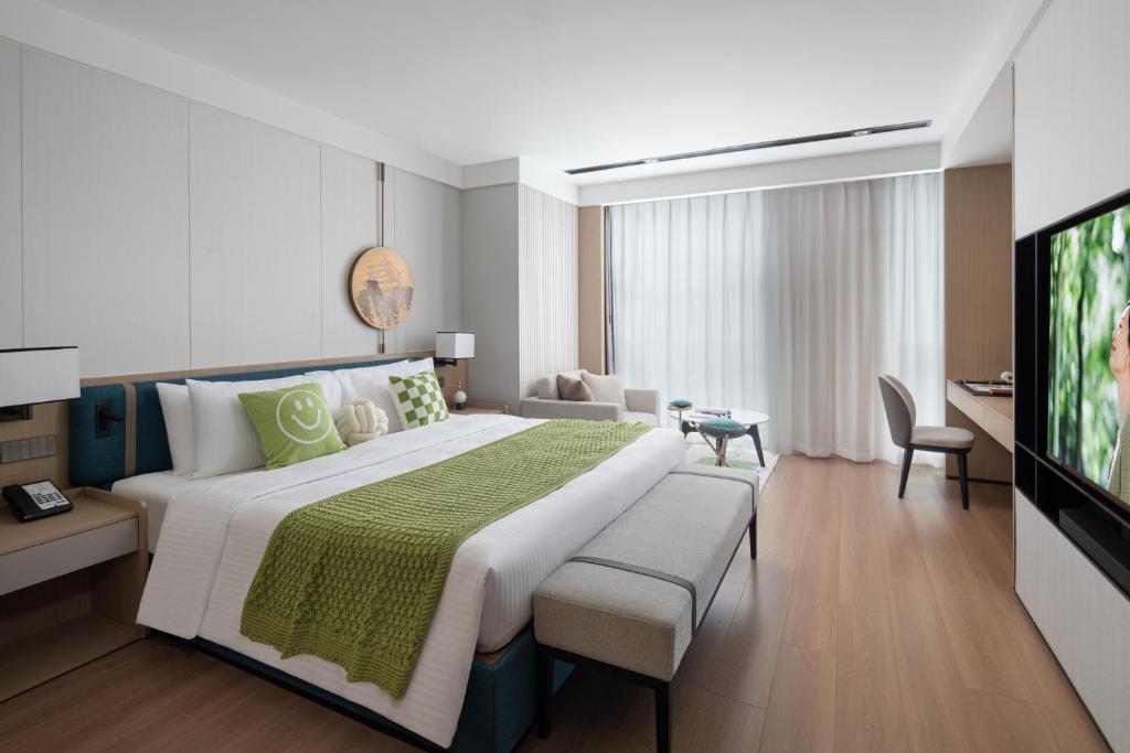a bedroom with a large bed and a television at Somerset Taihu New City CBD Wuxi in Wuxi