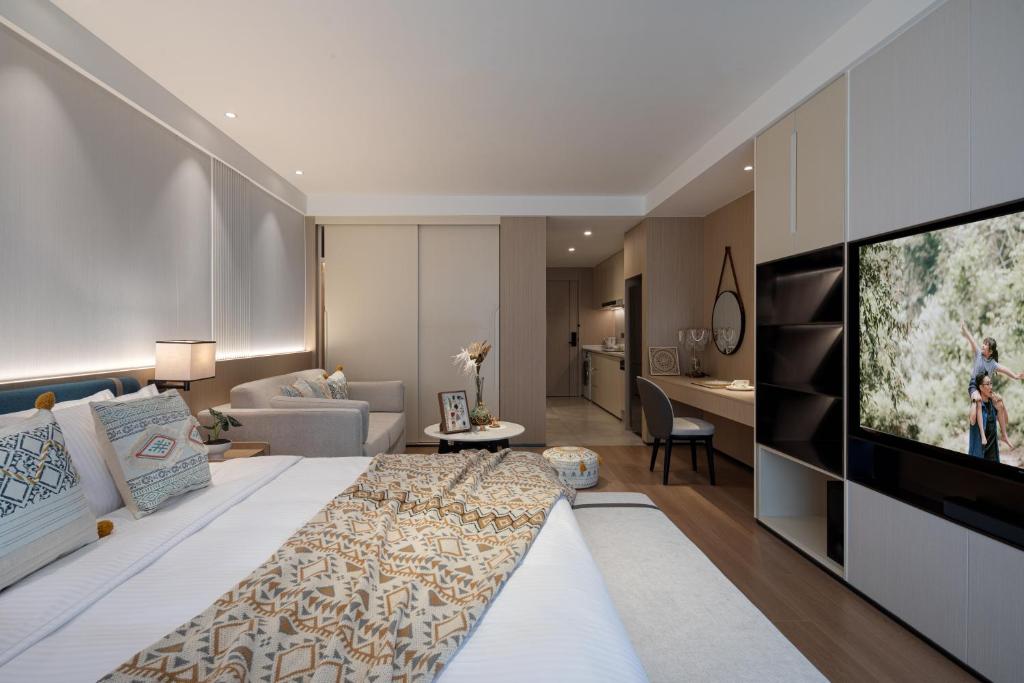 a hotel room with a large bed and a television at Somerset Taihu New City CBD Wuxi in Wuxi