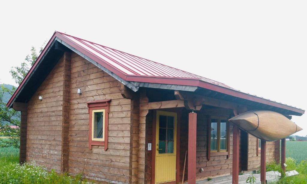 Cabaña de madera pequeña con puerta amarilla y roja en Log Cottage be with nature en Furano