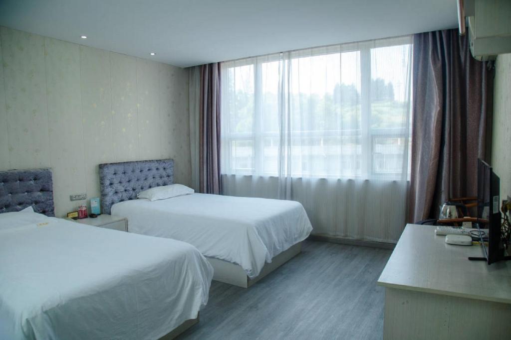 Postel nebo postele na pokoji v ubytování Wudangshan Daohe Inn