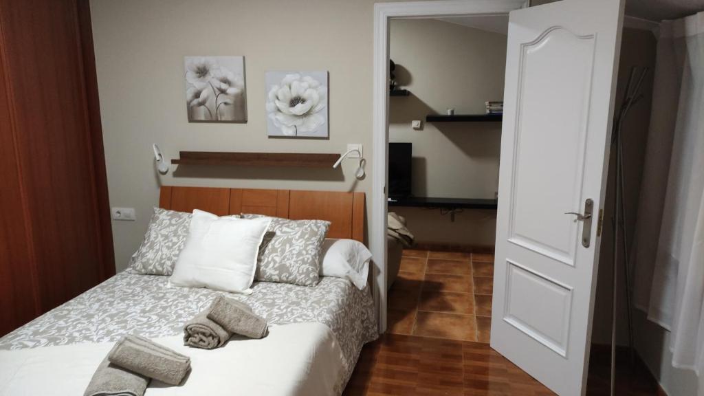Un pequeño dormitorio con una cama con toallas. en dunas da barra, en Ponteceso