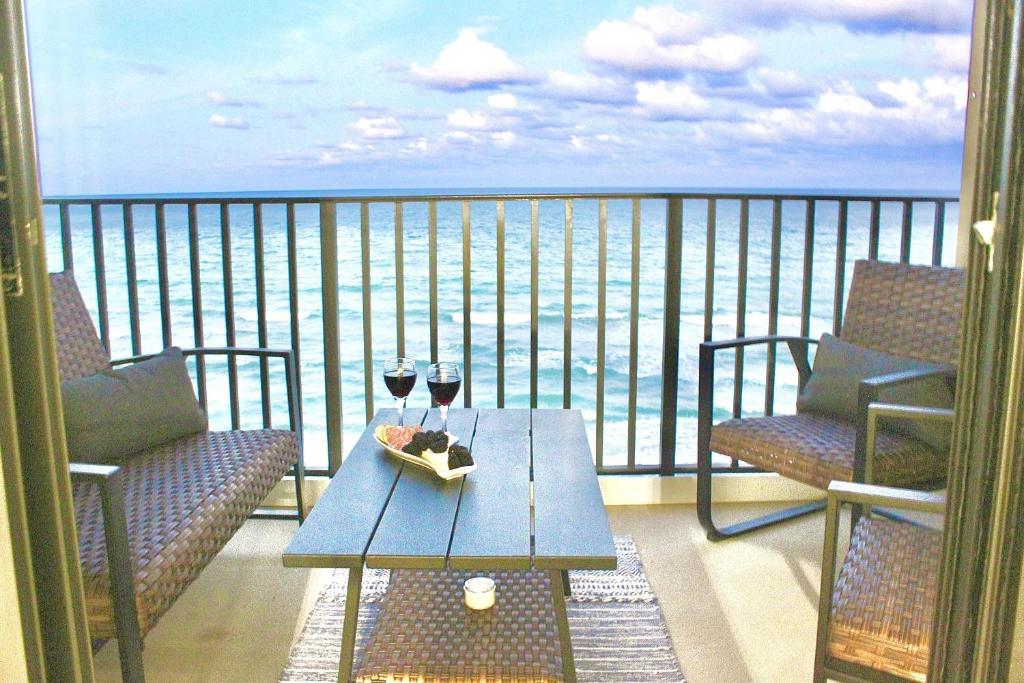 a balcony with a table and two glasses of wine at Ocean Breeze Condo in Jensen Beach