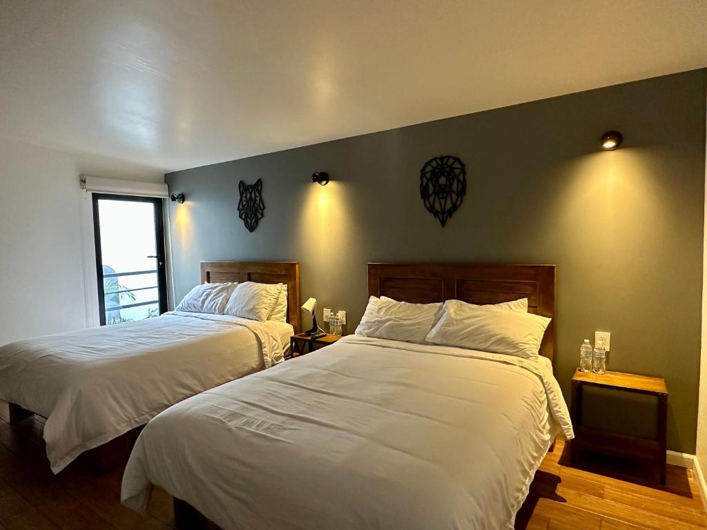 1 dormitorio con 2 camas con sábanas blancas en Casa Raffaello, en Ciudad de México